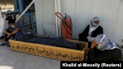 Ооруканадагы өрттөн көз жумган маркумдун cөөгү жана жакындары. 13-июль, 2021. Ирак.