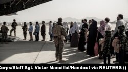 Evacuees wait to board a plane during an evacuation at Hamid Karzai International Airport in Kabul in August 2021. 