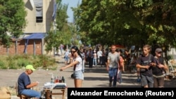 Вуличний торговець продає напої та овочі у Маріуполі