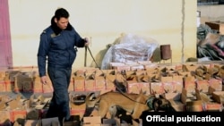 Armenia -- A photo released by the State Revenue Committee on March 3, 2021 shows an Armenian customs officer and a sniffer dog searching through boxes which authorities say contained heroin smuggled from Iran. 
