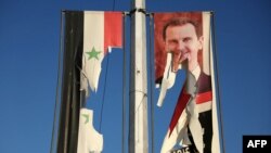 تصویر بشار اسد و پرچم سوریه در شهر حلب که از سوی مخالفان پاره شده است