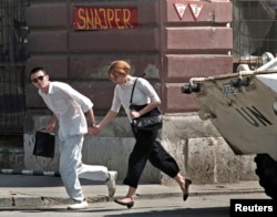 Млада двойка тича през т.нар. „Снайперистка алея“ в Сараево през 1995 г.