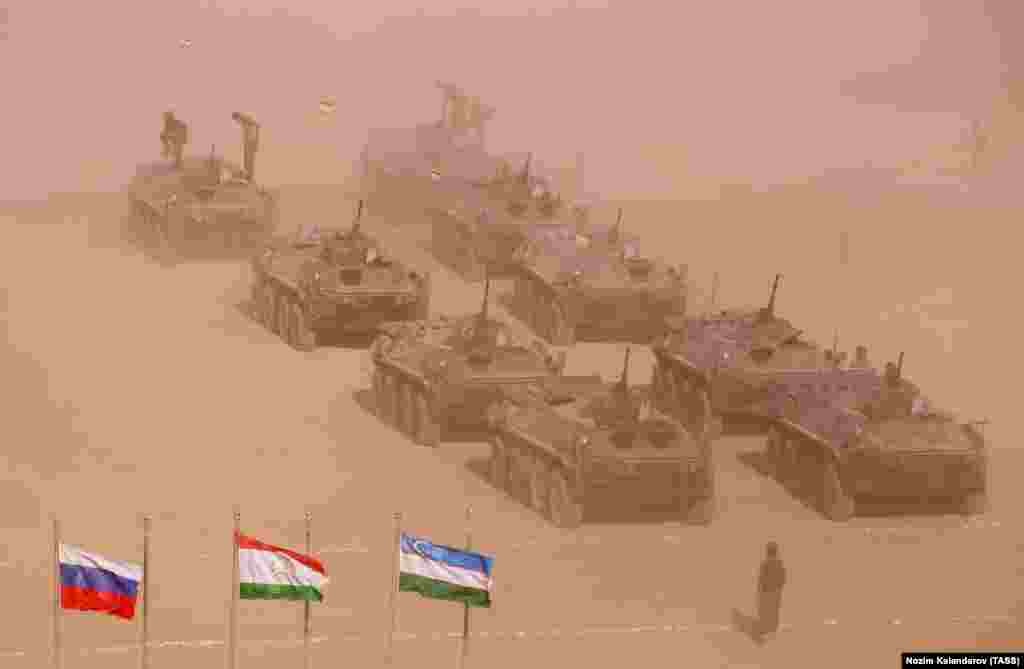 Tanks and troops mass at the Harb-Maidon training ground. The Russian (left to right), Tajik, and Uzbek flags are on display.