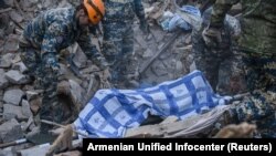 Куткаруучулар кагылышуулардын кесептинен каза болгон адамдын сөөгүн алып баратышат. Степанакерт. 6-ноябрь, 2020-жыл.