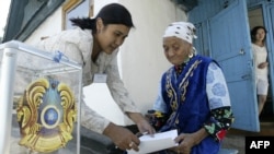 Член избирательной комиссии помогает пожилой женщине с бюллетенем во время парламентских выборов в Бес-Агаше. 18 августа 2007 года.
