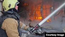 Рятувальники гасять пожежу, що виникла внаслідок удару РФ, Харків, травень 2025 року