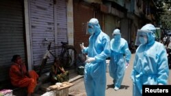 Медики в защитных костюмах в Мумбаи (Индия). 7 июня 2020 года.