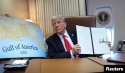 US President Donald Trump holds up a proclamation renaming the Gulf of Mexico as the Gulf of America on February 9.