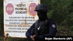 With rising tensions, a Kosovo police officer stands guard at the border crossing of Jarinje on September 20.