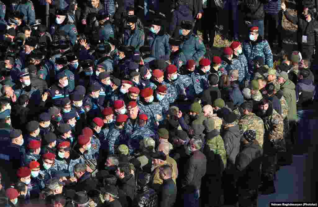 Armenian police stand guard as Pashinian pays his respects at the military cemetery on December 19.&nbsp;