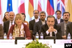 Ирандын ТИМинин орун басары Аббас Арагчи (оңдо) жана Евробиримдиктин Тышкы иш-аракет кызматынын Башкы катчысы Хелга Шмид (солдо) “БААПтын” отурумунда. (Ага Германия, Иран, Кытай, Орусия, Улуу Британия жана Франция катышты). Вена ш., Австрия. 2019-жылдын 28-июну.