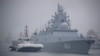 A tugboat escorts the Russian frigate Admiral Gorshkov as it prepares to dock at a port in Qingdao, China in 2019. 