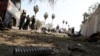 Afghan policemen inspect the scene after a deadly blast in Jalalabad on March 19. 