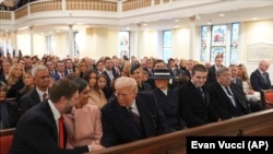 Donald Trump shakes hands with Vice President-elect JD Vance as he arrives for a service at St. John's Church in Washington D.C.