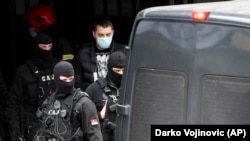 Serbian police escort detained Partizan fan leader Veljko Belivuk (center) during a raid on the Partizan stadium in Belgrade on February 4.