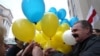 Belarusian opposition protesters share blue and yellow balloons to show their solidarity with Ukraine, during a rally marking the unofficial Freedom Day in Minsk on March 25. 