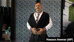 Александр Усик в образе украинского козака демонстрирует свои будущие чемпионские пояса перед совместной пресс-конференцией с британцем Энтони Джошуа в Джидде, Саудовская Аравия, август 2022 год