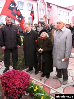 Під час відкриття пам’ятника головнокомандувачу УПА генералу Роману Шухевичу в селі Княгиничі на Івано-Франківщині, 13 листопада 2005 року. На фото: його син Юрій Шухевич (другий ліворуч) та колишні зв’язкові УПА Ольга Ільків і Любомир Полюга. У селі Княгиничах Роман Шухевич перебував із жовтня 1946-го по вересень 1947 року
