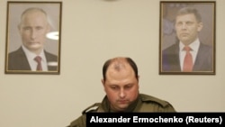 Дмитро Трапезников, «виконувач обов’язків» ватажка угруповання «ДНР», що визнане в Україні терористичним, між портретами живого Володимира Путіна і вбитого Олександра Захарченка. Окупований Донецьк, 31 серпня 2018 року