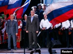 Володимир Константинов (ліворуч) та Сергій Аксьонов на сцені під час оголошення попередніх результатів так званого «референдуму про приєднання до Росії». Сімферополь, 16 березня 2014 року