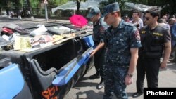 Armenia - Valeri Osipian, deputy chief of the Yerevan police, inspects trash containers used as a barricade by protesters on Marshal Bagramian Avenue, Yerevan, 28Jun2015.