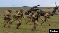 British soldiers disembark from a US military helicopter during the Wind Spring 15 NATO military exercises in Romania on April 21.