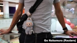 Чалавек з прымацаванай да сумкі лялькай Лабубу каля флягманскай крамы Pop Mart у Шанхаі, Кітай, 13 чэрвеня 2025 году