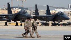 افسران ارتش عربستان از مقابل جنگنده‌های اف-۱۵ می‌گذرند؛ ریاض، ژانویه ۲۰۱۷