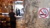 Montenegro -- A "no smoking" sign stands on a wall as a man waits at a bar counter in Podgorica, August 14, 2019