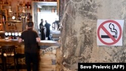 Montenegro -- A "no smoking" sign stands on a wall as a man waits at a bar counter in Podgorica, August 14, 2019