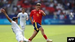 Абдуқодир Ҳусанов 2024 йилги Париж олимпиадасида Ўзбекистон жамоасининг Испанияга қарши ўйинида дунёнинг энг тез ўйинчиларидан бўлган Фермин Лопесдан тўпни олиб қўйяпти.