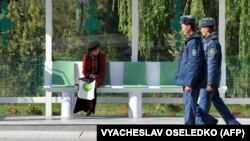 Aşgabadyň awtobus duralgalarynyň birinde oturan talyp gyz we polisiýa işgärleri (Illýustrasiýa suraty)