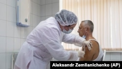  Медицина қызметкері еріктіге  "Спутник V" вакцинасын салып жатыр. Мәскеу, Ресей. 15 қыркүйек, 2020
