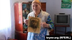 Sürgün olunğan Abibe Mustafayeva cenkte elâk olğan babasınıñ fotoresimi ile