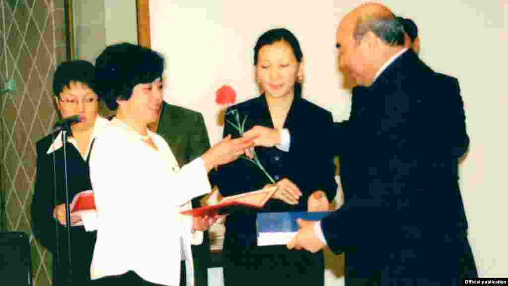 Бывший президент Аскар Акаев вручает цветы Бюбюкан Досалиевой.