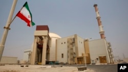 An Iranian flag flutters in front of the reactor building of the Bushehr nuclear power plant. (file photo)