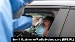 Замер температуры тела на пропускном пункте. Иллюстративное фото.