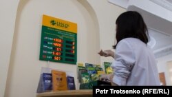Сотрудник Народного банка в Алматы меняет курс валюты