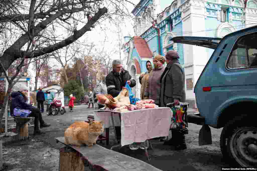 Христиандар чиркөө алдында соода кылып жатат.