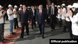 Armenia - President Serzh Sarkisian (R) and Orinats Yerkir Party leader Artur Baghdasarian are greeted by party activists at an event in Yerevan, 20Mar2012.