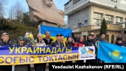 Собравшиеся в поддержку Украины активисты в Алматы развернули плакат с надписью «Пусть война в Украине прекратится». 24 февраля 2025 года