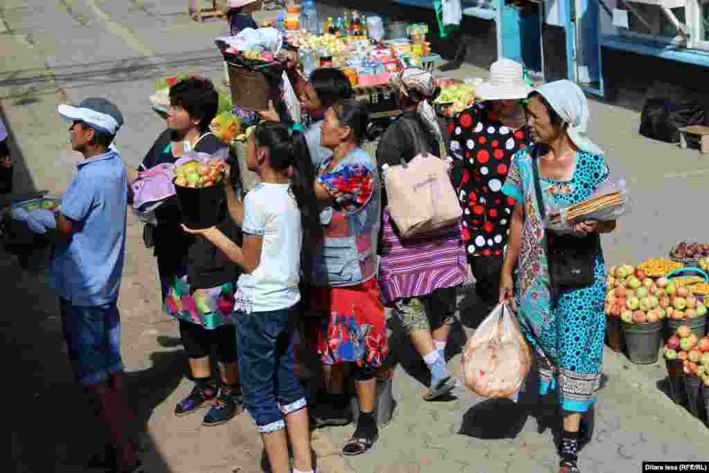 Торговцы из числа местных жителей предлагают пассажирам поезда купить яблоки.