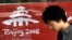 China -- A pedestrian walks past a banner promoting the Beijing 2008 Olympic Games tickets in Beijing, 15Apr2007