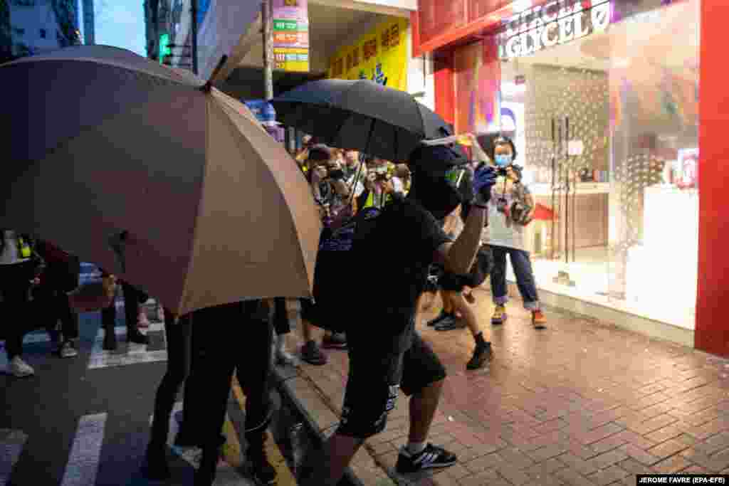 Протестувальник готується жбурнути &laquo;коктейль Молотова&raquo; у вітрину крамниці, пов&rsquo;язаної з Китаєм. 1 липня в Гонконгу відбулися протести проти нового закону про нацбезпеку, розробленого спеціально для Гонконгу. Закон напередодні підписав голова Китаю Сі Цзіньпін