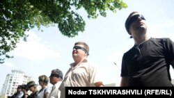 «Встаньте шире!» - с этими словами сотрудники «Алия Холдинга» выстроились перед зданием МВД в Тбилиси