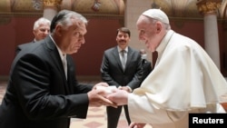 Pope Francis (right) shakes hands with Hungarian Prime Minister Viktor Orban at Romanesque Hall in the Museum of Fine Arts in Budapest on September 12.