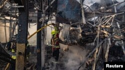 Рятувальники гасять пожежу після однієї з попередніх російських атак по Сумщині, архівне фото