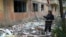 A woman stands near her apartment building, which was damaged in a night attack in the town of Selydove, in Ukraine's Donetsk region, on April 14.