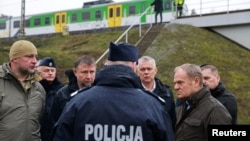Прем'єр-міністр Польщі Дональд Туск (праворуч) оглядає місце пошкодження залізничних колій на лінії Варшава-Люблін після вибуху, який він назвав «безпрецедентним актом диверсії».