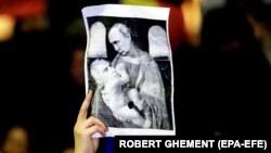 Плакат, на якому зображений керівник Росії Володимир Путін і Келін Джорджеску, який пройшов до другого туру на виборах президента Румунії, на акції протесту в румунській столиці. Бухарест, 25 листопада 2024 року 